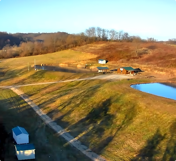 Rural landscape with hills and small buildings.